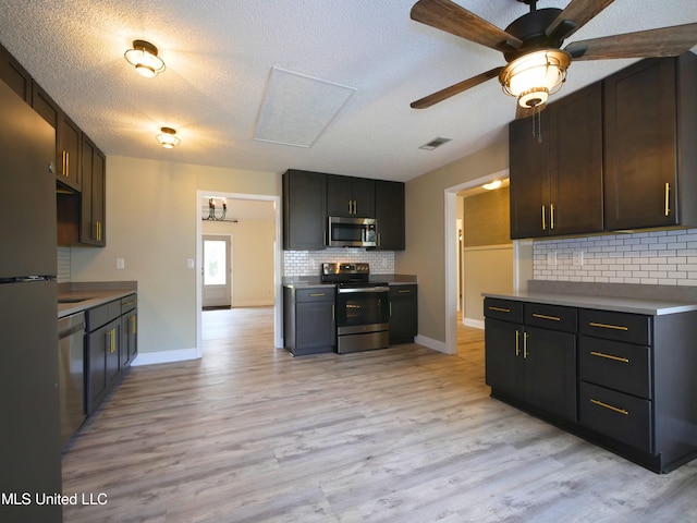 kitchen with tasteful backsplash, visible vents, light wood-style flooring, appliances with stainless steel finishes, and a ceiling fan