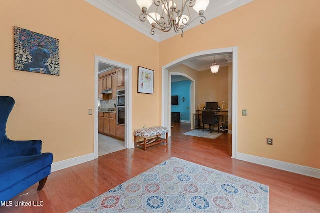 63722 N Diamondhead Dr, Diamondhead, MS 39525 - living area featuring arched walkways, ornamental molding, light wood finished floors, a chandelier, and baseboards
