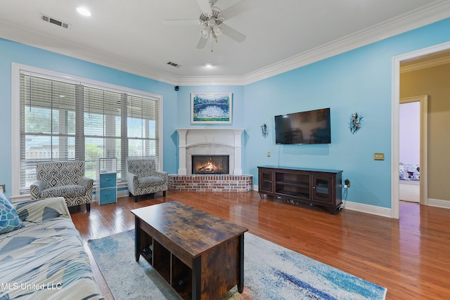 63722 N Diamondhead Dr, Diamondhead, MS 39525 - living area featuring a ceiling fan, crown molding, wood finished floors, a brick fireplace, and baseboards