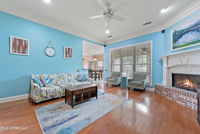 63722 N Diamondhead Dr, Diamondhead, MS 39525 - living room with ceiling fan, baseboards, wood finished floors, crown molding, and a brick fireplace