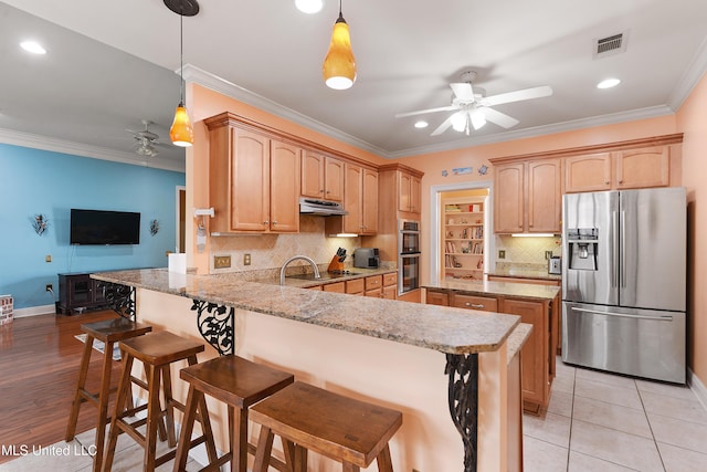 63722 N Diamondhead Dr, Diamondhead, MS 39525 - kitchen featuring appliances with stainless steel finishes, a ceiling fan, under cabinet range hood, a peninsula, and recessed lighting