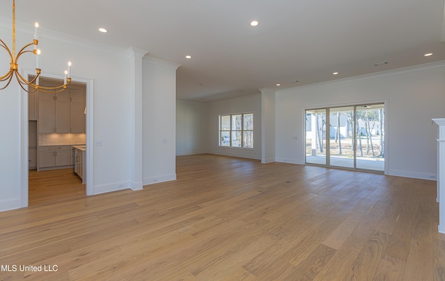 unfurnished room with ornamental molding, light hardwood / wood-style flooring, and a notable chandelier