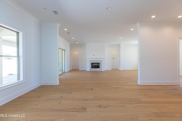 unfurnished living room featuring crown molding and light wood-type flooring