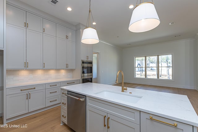 kitchen with light stone counters, sink, backsplash, and hanging light fixtures