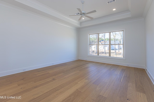 unfurnished room with crown molding, ceiling fan, a raised ceiling, and light hardwood / wood-style floors