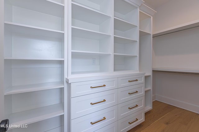 walk in closet with hardwood / wood-style floors