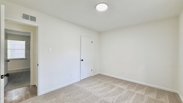 carpeted spare room featuring baseboards