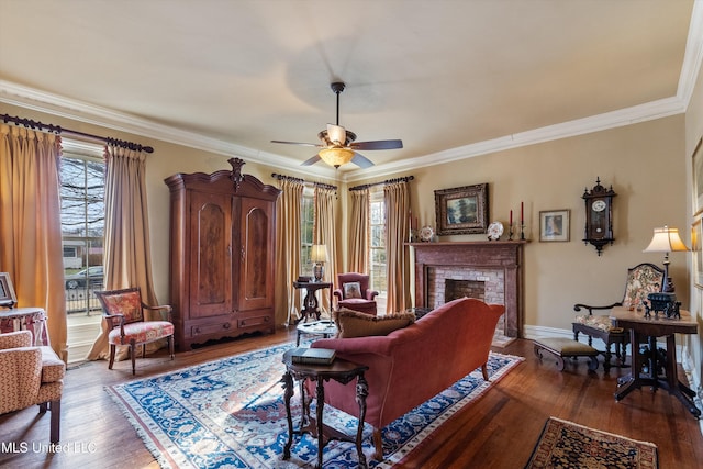 living area with ornamental molding, wood-type flooring, and a fireplace