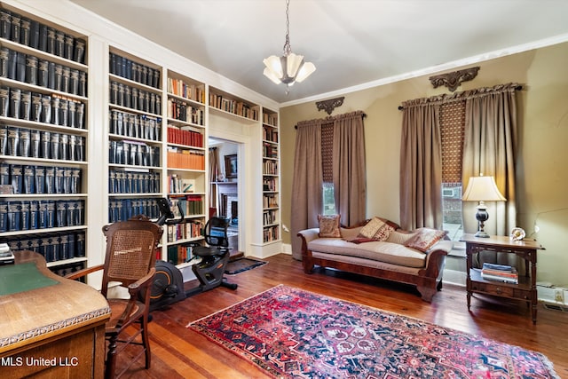 office featuring ornamental molding, a fireplace, a notable chandelier, and wood finished floors