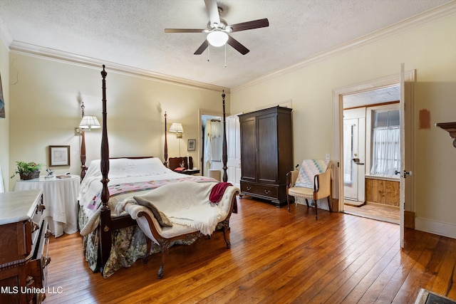 bedroom featuring a textured ceiling, hardwood / wood-style floors, baseboards, and crown molding