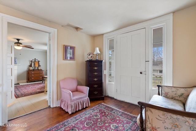 sitting room featuring baseboards, dark wood finished floors, and a ceiling fan