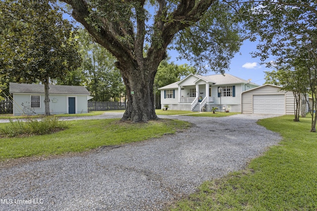 866 Washington St, Bay Saint Louis, MS 39520 - view of front of house with an outdoor structure, driveway, a garage, and covered porch