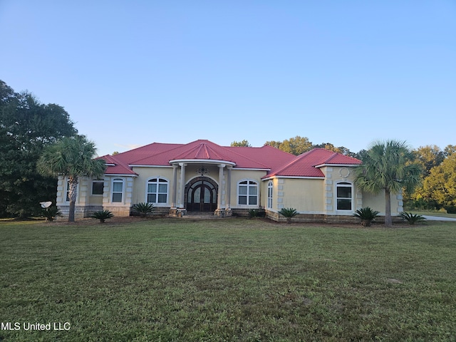 mediterranean / spanish-style house with a front yard