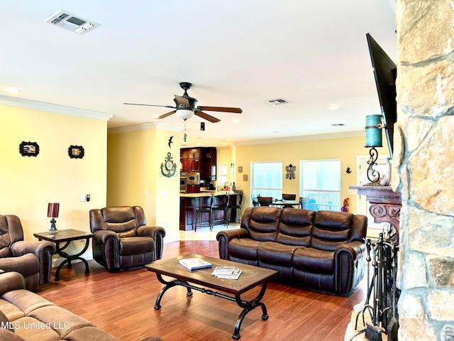 living room featuring crown molding, wood-type flooring, and ceiling fan