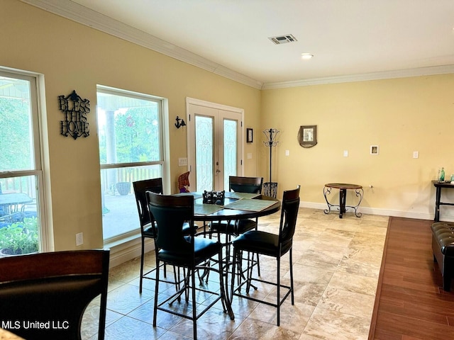 dining room featuring french doors, ornamental molding, light hardwood / wood-style flooring, and plenty of natural light