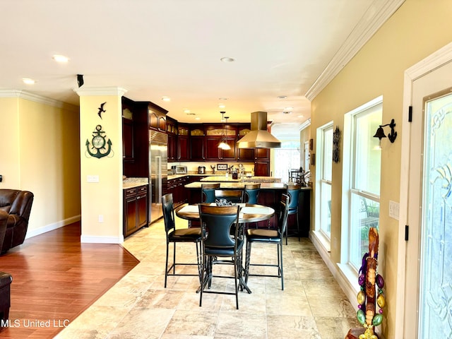 dining space with ornamental molding and light wood-type flooring