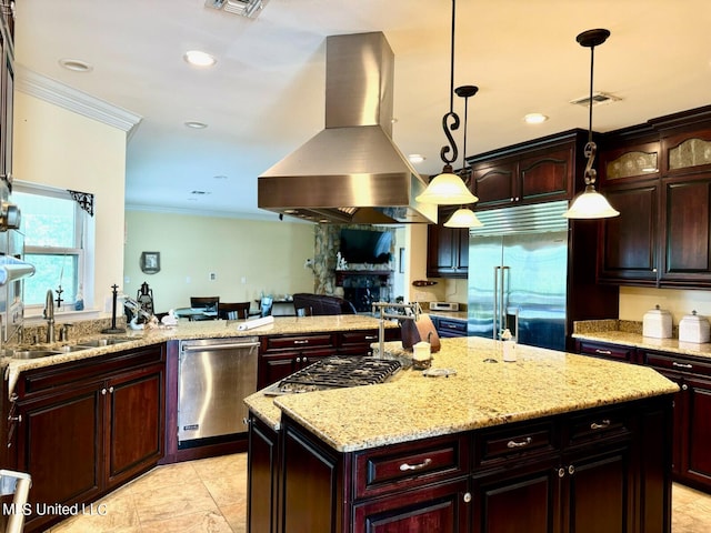 kitchen featuring island range hood, stainless steel appliances, a center island, decorative light fixtures, and light stone counters