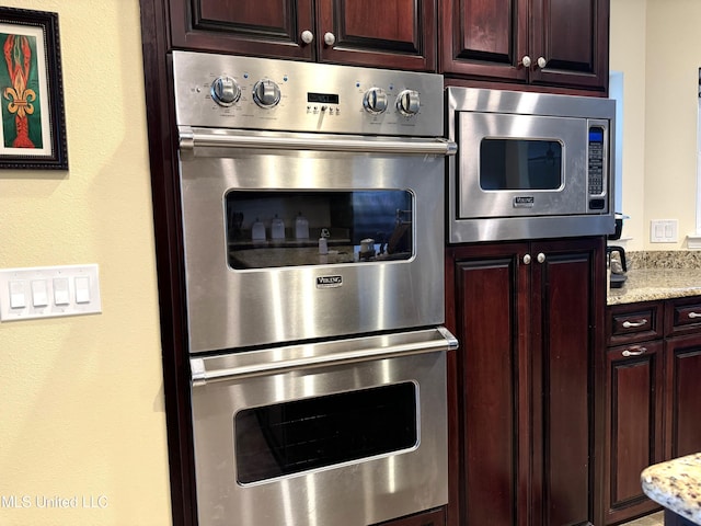 kitchen with appliances with stainless steel finishes and light stone counters