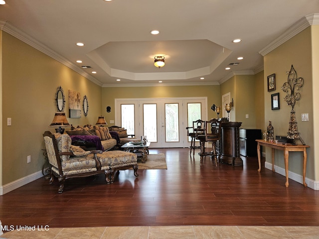 living room featuring french doors, crown molding, a raised ceiling, and hardwood / wood-style floors