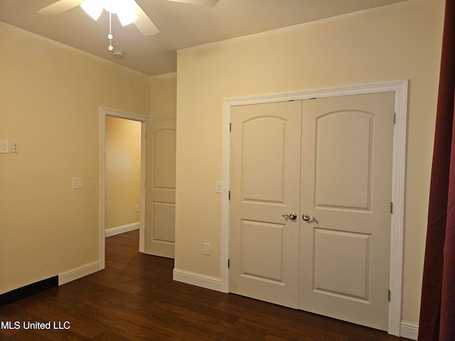 unfurnished bedroom with a closet, ceiling fan, and dark hardwood / wood-style flooring