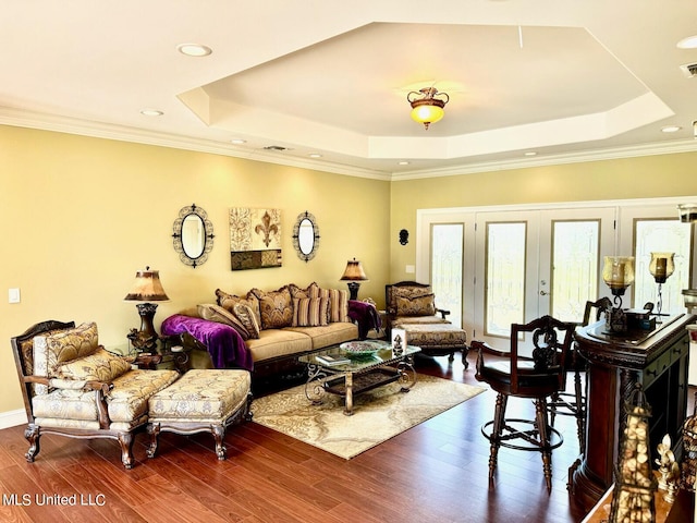 living room with ornamental molding, french doors, a raised ceiling, and dark hardwood / wood-style flooring