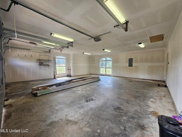 garage with a garage door opener and electric panel