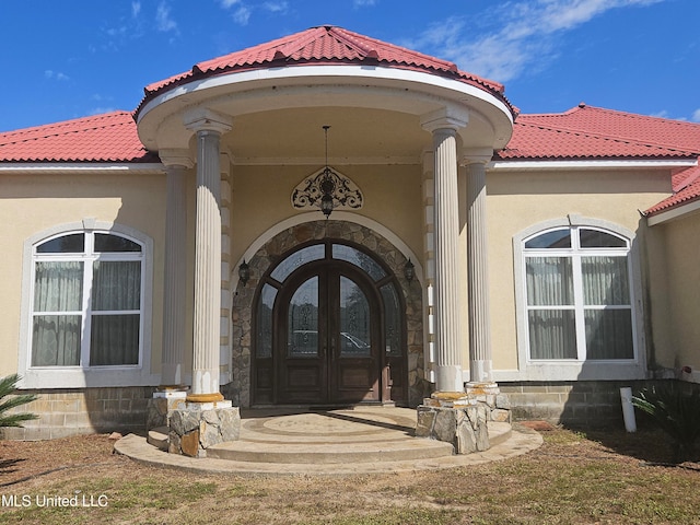 property entrance featuring french doors and covered porch