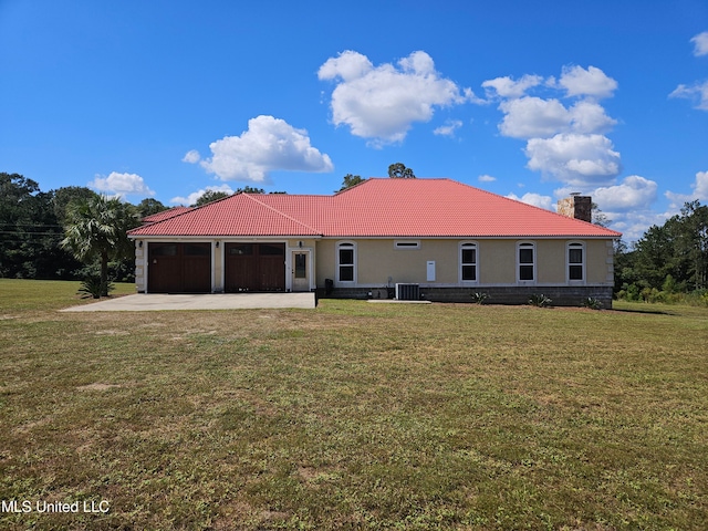 view of front facade featuring central air condition unit, a front yard, and a garage