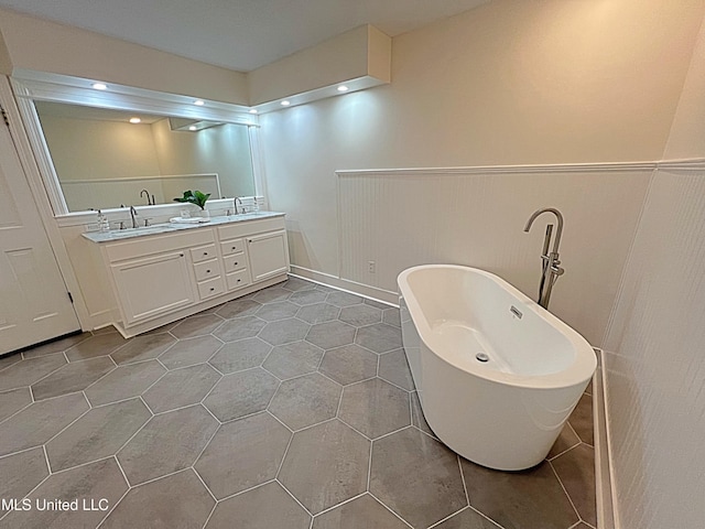 bathroom with tile patterned flooring, vanity, and a tub