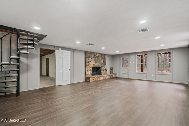 unfurnished living room featuring a fireplace and dark wood-type flooring