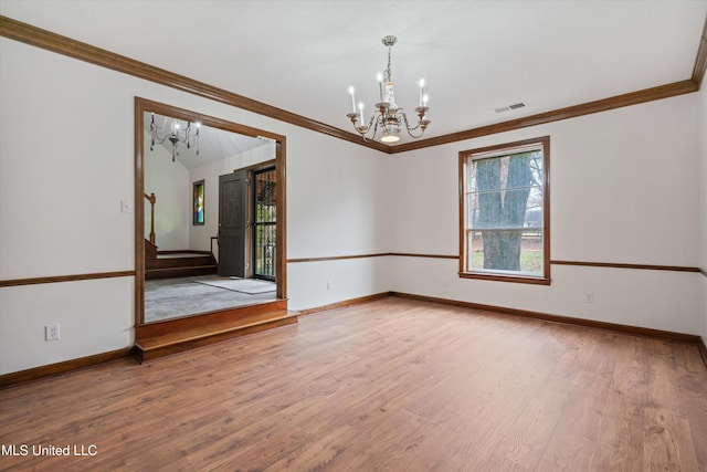 unfurnished room featuring hardwood / wood-style floors, a notable chandelier, and ornamental molding