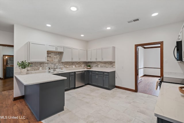 kitchen featuring kitchen peninsula, light wood-type flooring, gray cabinetry, sink, and dishwasher