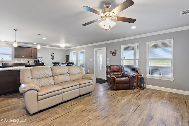 living room with a healthy amount of sunlight, visible vents, and light wood-style floors