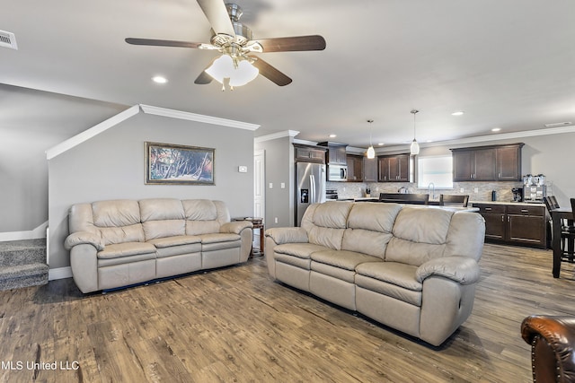 living area with recessed lighting, visible vents, baseboards, dark wood-style floors, and crown molding