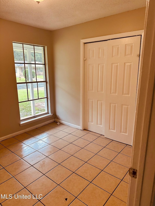 143 James Dr, Gulfport, MS 39503 - unfurnished bedroom with a textured ceiling, light tile patterned floors, baseboards, and a closet