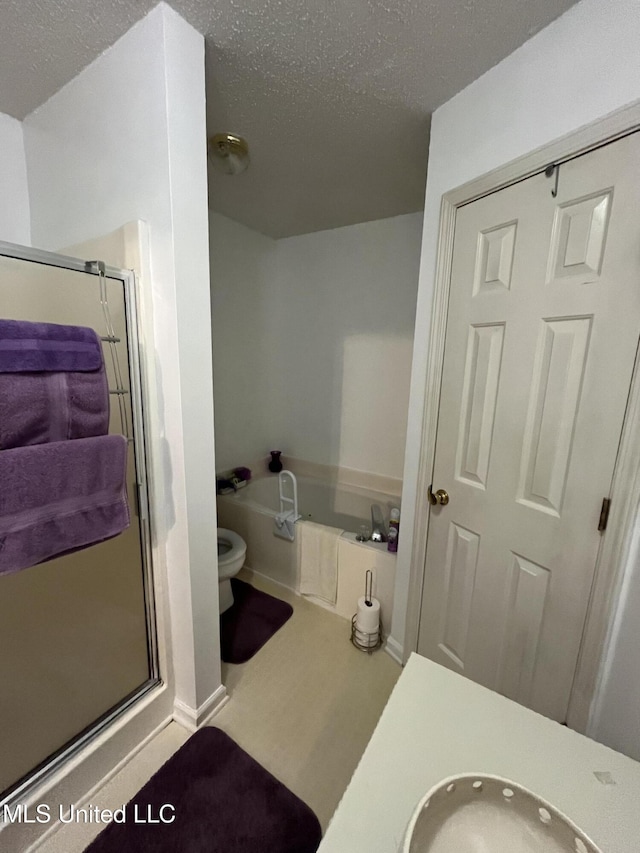 7605 Davis Pkwy, Southaven, MS 38671 - bathroom featuring a bath, a stall shower, a textured ceiling, and vanity