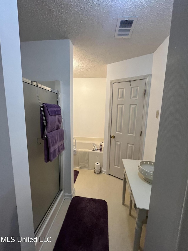 7605 Davis Pkwy, Southaven, MS 38671 - bathroom with a shower stall, a textured ceiling, a bath, and vanity