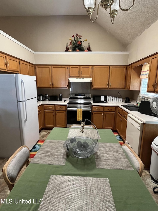 7605 Davis Pkwy, Southaven, MS 38671 - kitchen featuring white appliances, under cabinet range hood, brown cabinetry, light countertops, and a chandelier