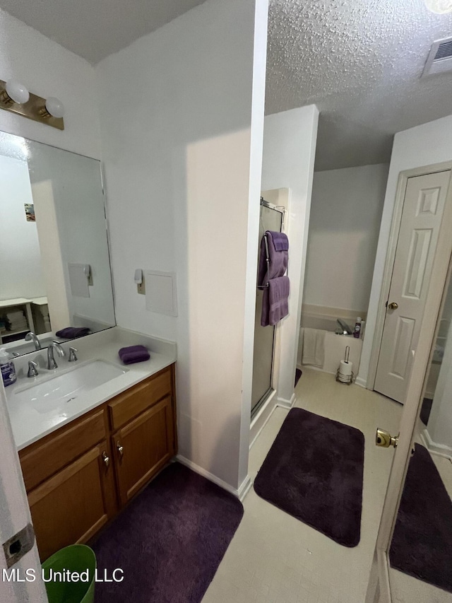 7605 Davis Pkwy, Southaven, MS 38671 - bathroom featuring a shower stall, vanity, and a textured ceiling