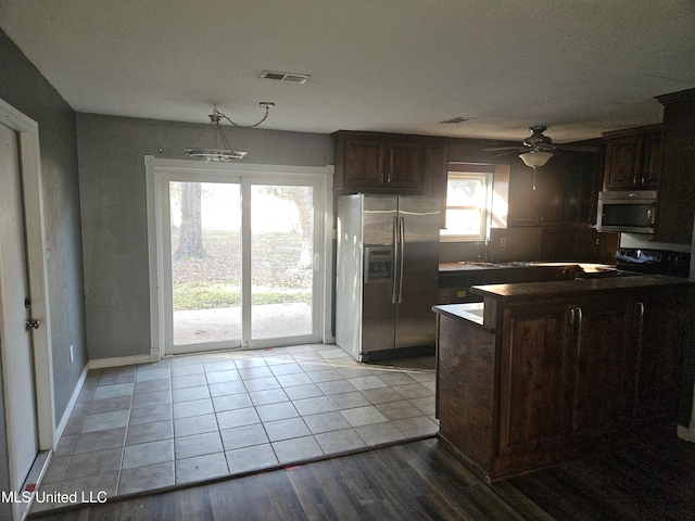 kitchen with appliances with stainless steel finishes, dark brown cabinetry, light hardwood / wood-style flooring, and ceiling fan