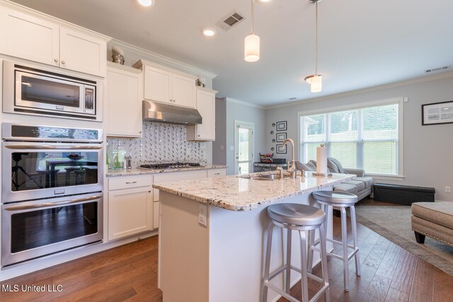 kitchen with white cabinetry, appliances with stainless steel finishes, dark hardwood / wood-style flooring, and hanging light fixtures