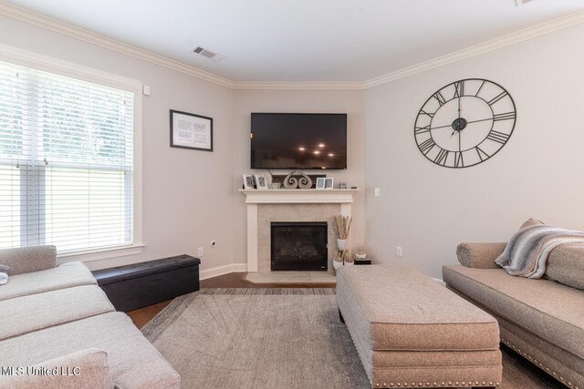 living room with crown molding, hardwood / wood-style floors, and a fireplace