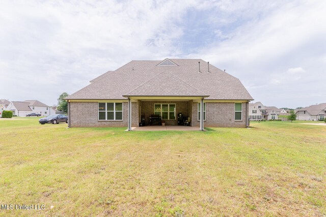 rear view of property featuring a patio area and a lawn