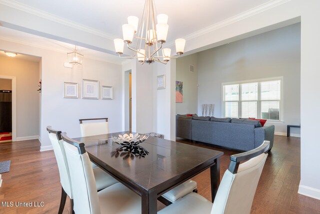 dining space with crown molding, a chandelier, and dark hardwood / wood-style floors