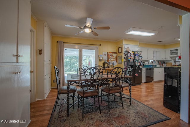 dining area featuring a ceiling fan, ornamental molding, and light wood-type flooring