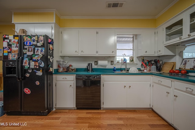 kitchen featuring ornamental molding, a sink, light wood-style floors, visible vents, and black appliances