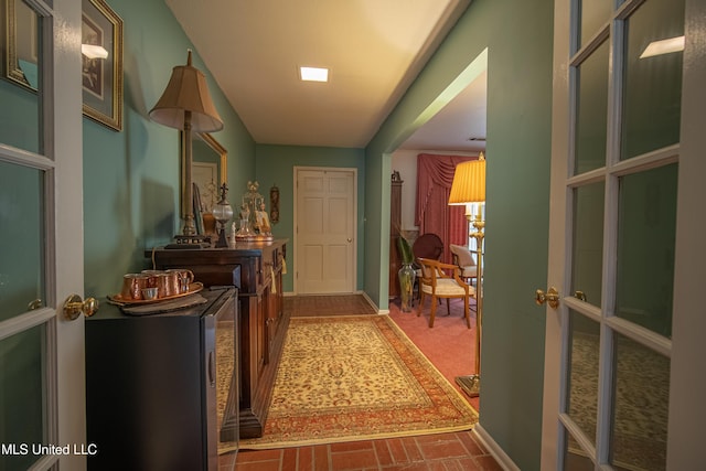 interior space with baseboards and brick floor