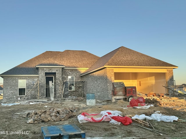 view of front of home with brick siding and a shingled roof