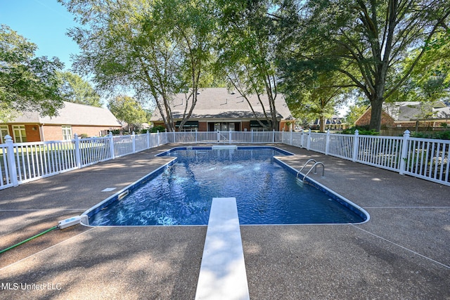 view of pool featuring a patio area and a diving board