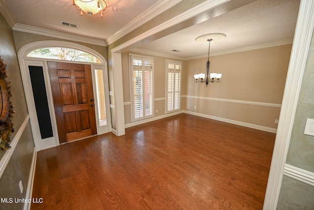 entryway featuring a textured ceiling, ornamental molding, and dark hardwood / wood-style floors